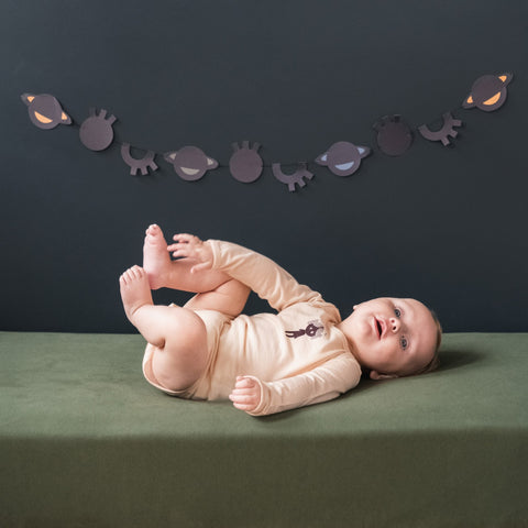merino baby girl wearing a long sleeve bodysuit soft peach with print