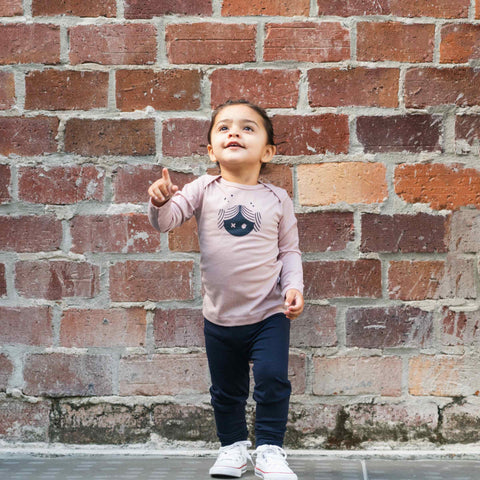 Girl wearing merino baby long sleeve top blush pink with print