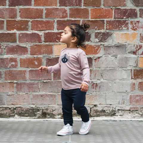 Girl wearing merino legging and merino baby long sleeve top blush pink with print