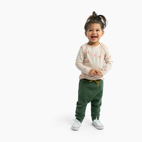 Girl wearing merino baby long sleeve top dusky peach with ghost print