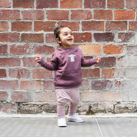 Child wearing merino baby slouch pants blush pink with print
