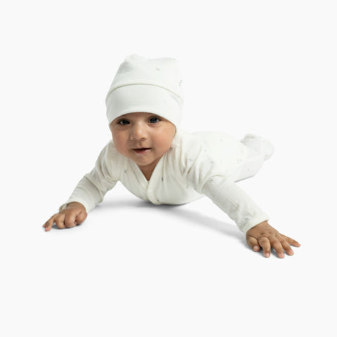 baby wearing merino baby hat natural white with allover x print