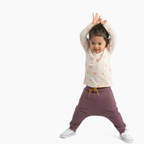 Girl wearing organic cotton merino baby slouch trackie plum with print