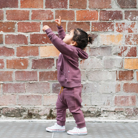 Girl wearing organic cotton merino baby slouch trackie plum