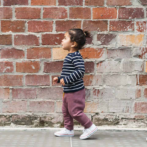 Child wearing organic cotton merino baby slouch trackie plum
