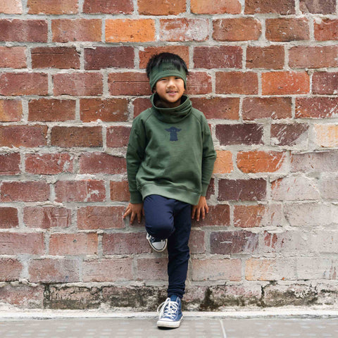 Boy wearing a cotton merino headband in olive