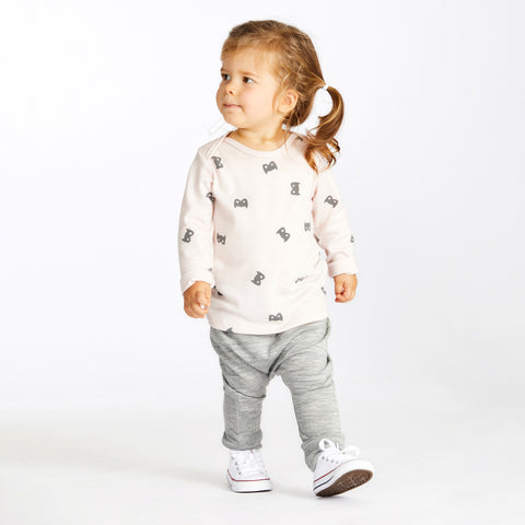 Girl wearing merino baby long sleeve top powder pink with print
