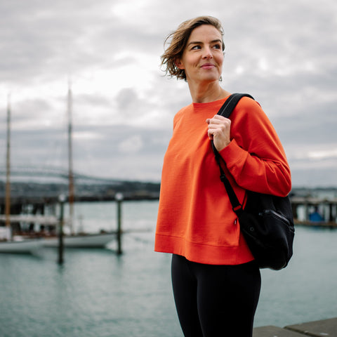 Woman wearing organic cotton merino women's top in tangerine orange