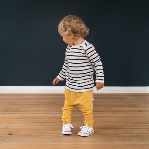 Child wearing merino baby slouch pants canary yellow