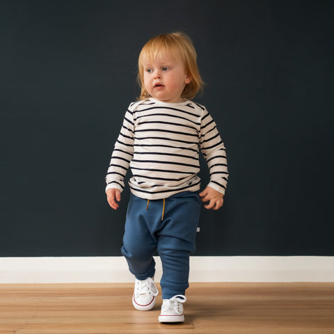 Child wearing trackies and merino baby long sleeve top natural white Breton stripe
