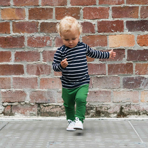 Child wearing merino baby long sleeve top navy Breton stripes