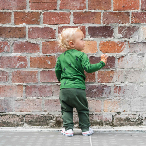 Child wearing merino baby long sleeve top moss green with print
