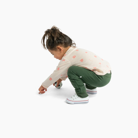 Child wearing trackies and merino baby long sleeve top dusky peach with ghost print