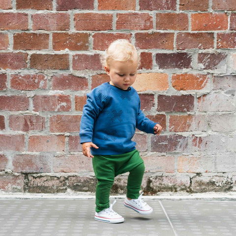 Boy wearing merino baby slouch pants moss green
