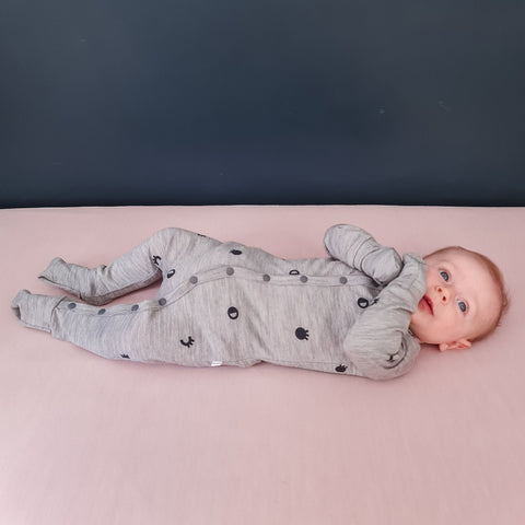 Baby wearing merino baby sleepsuit grey marl with print