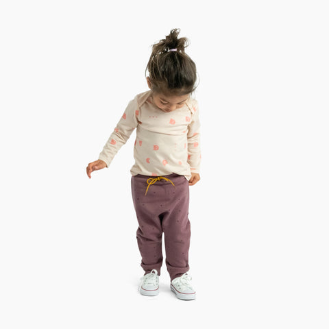 Child wearing organic cotton merino baby slouch trackie plum with print