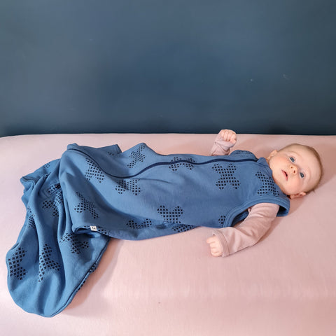 Baby wearing organic cotton merino sleep sack denim blue