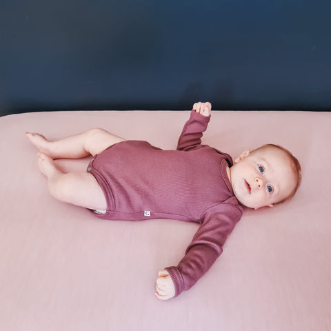 Baby wearing Organic cotton long sleeve bodysuit plum
