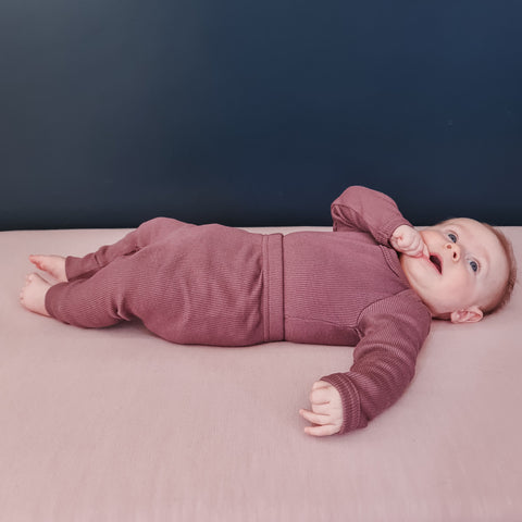Baby wearing bodysuit and organic rib cotton leggings plum